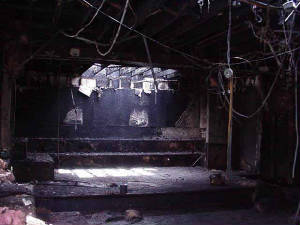 A dark, shadowy, broken old warehouse.